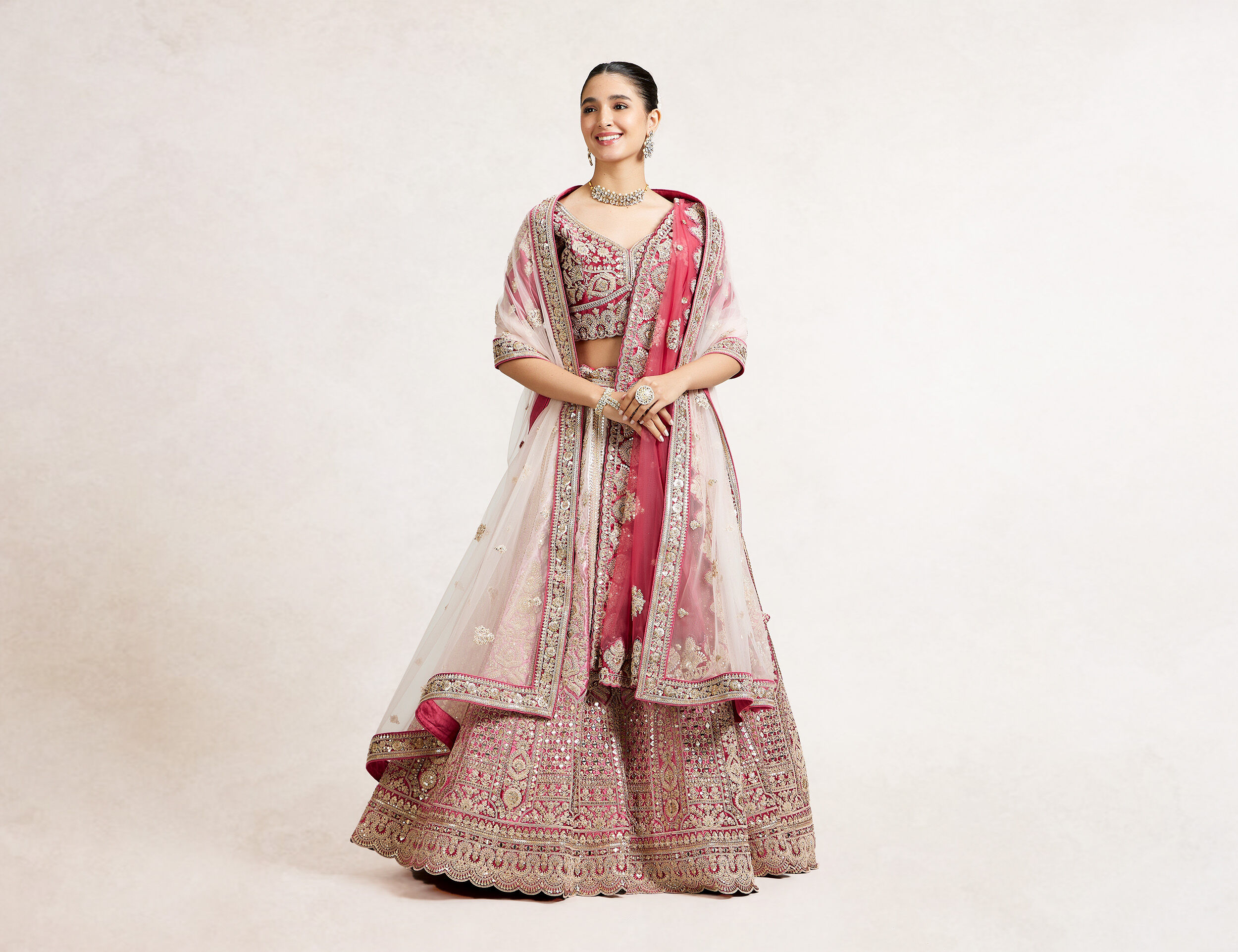A bride in mix colour bridal lehenaga with elegant pink dupatta